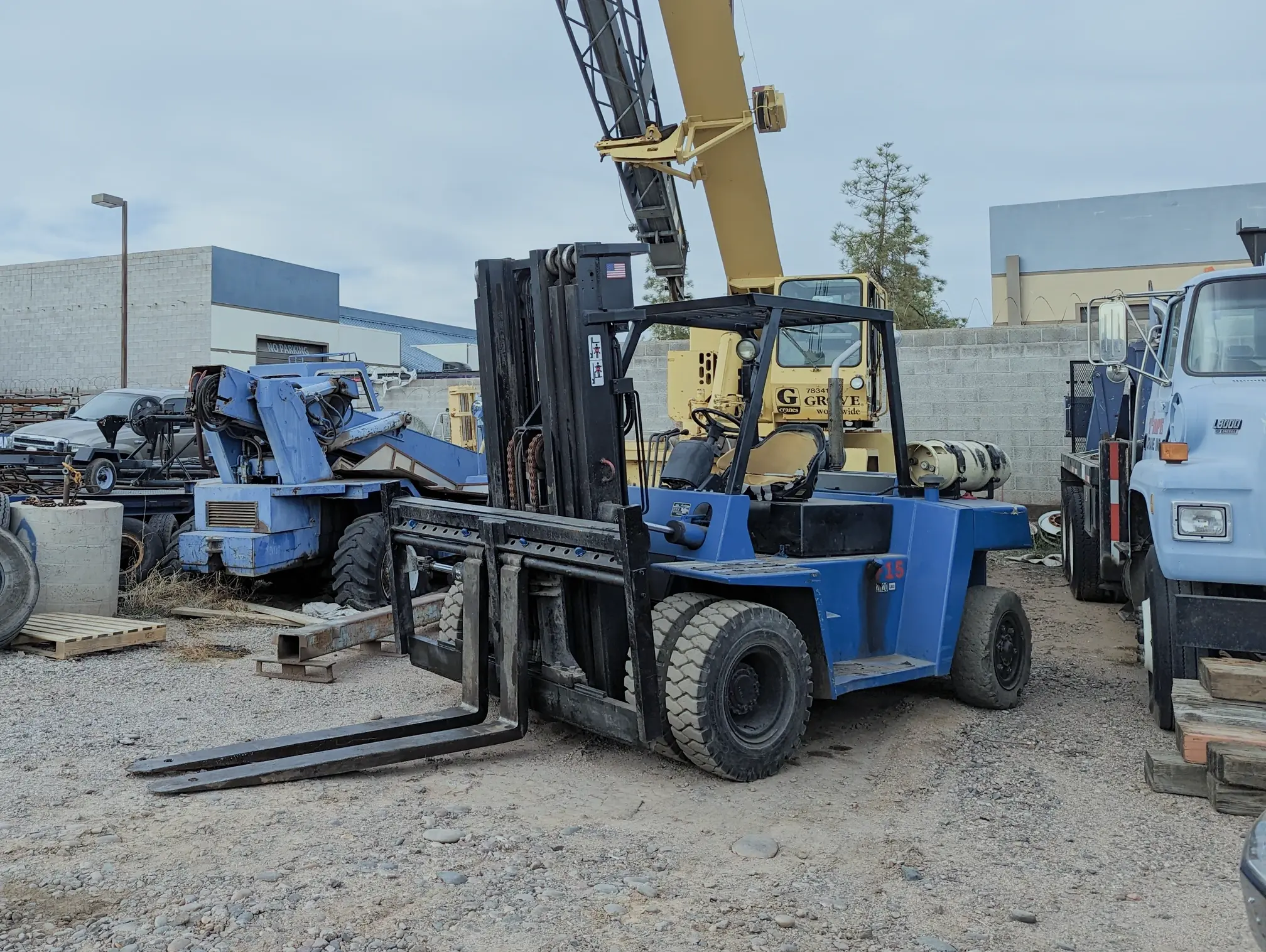 A forklift parked in the yard, amid a variety of equipment, showcasing its fundamental role in operations.