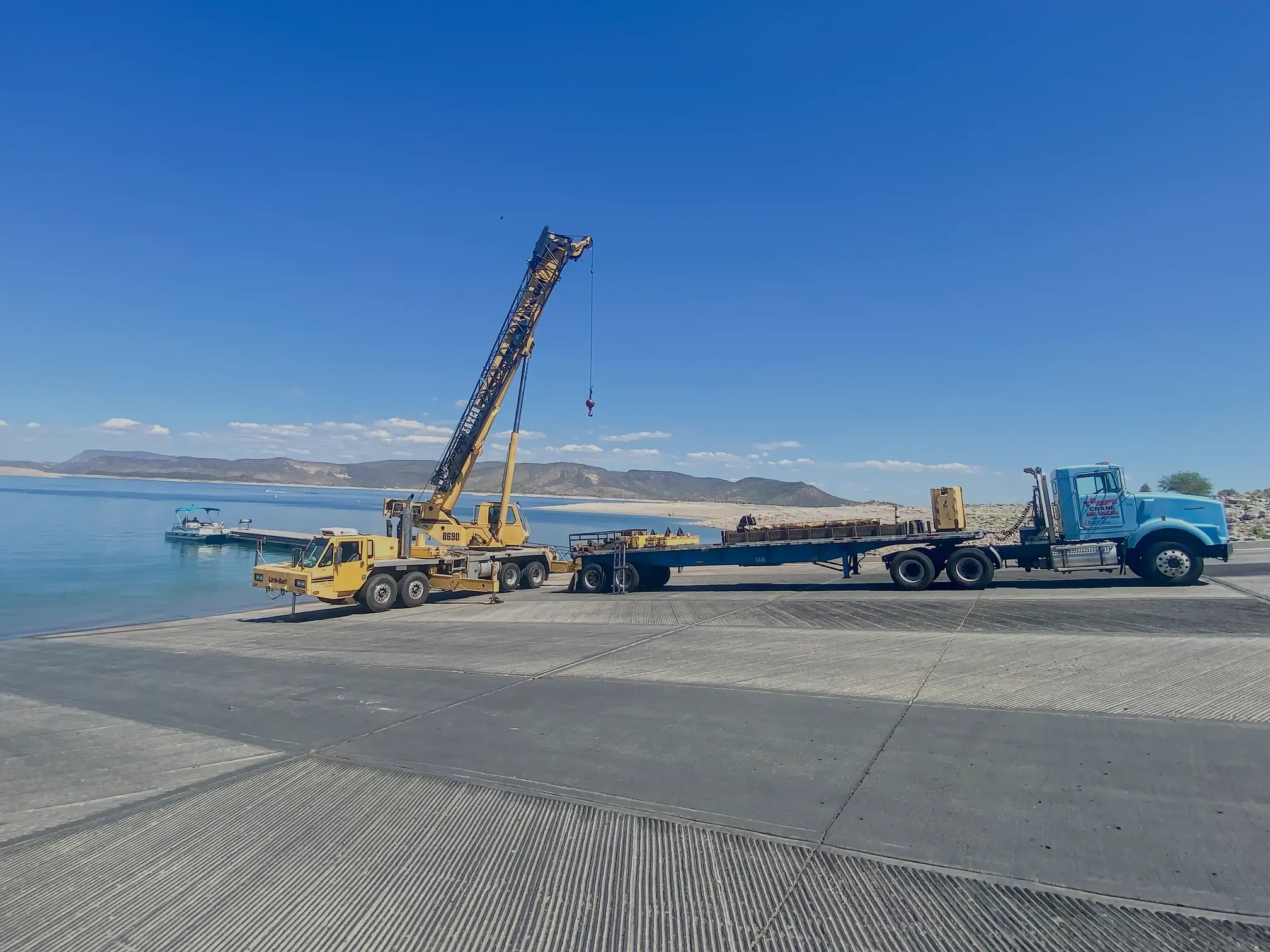 A crane prepared at a boat ramp, ready to assist in a boat recovery operation, demonstrating our versatility in marine services.
